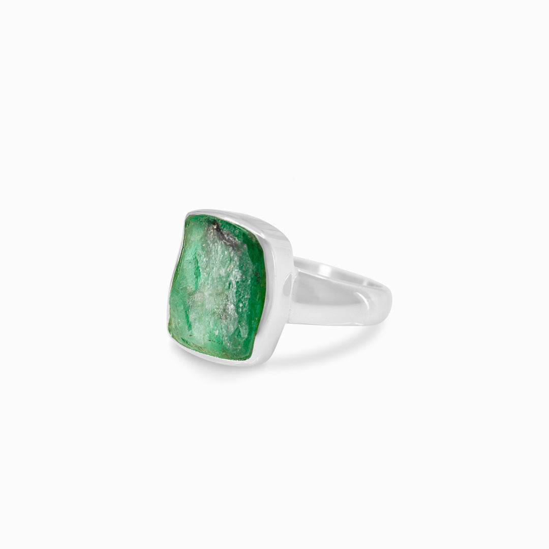 Silver ring with a green gemstone on a white background