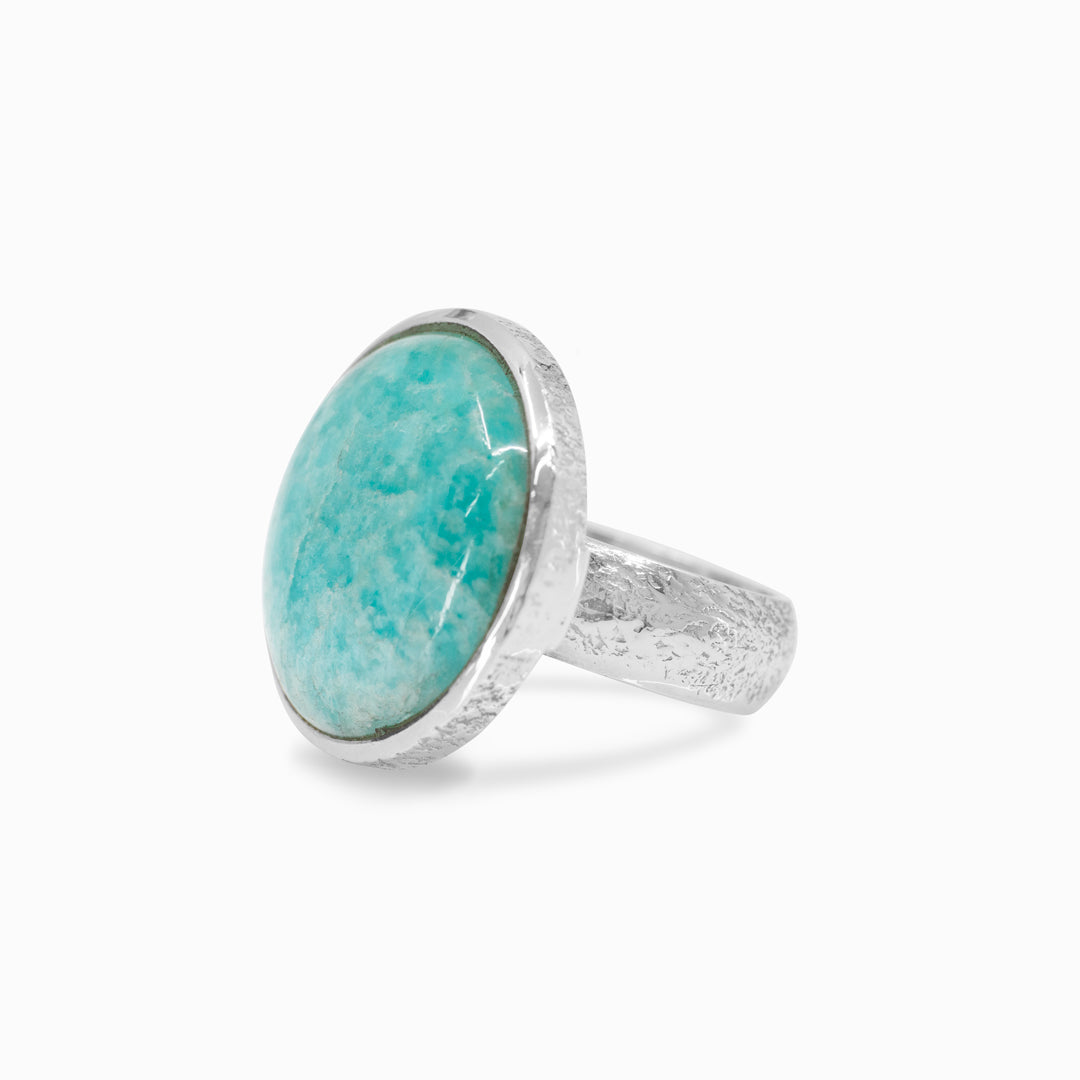 Silver ring with a green gemstone on a white background