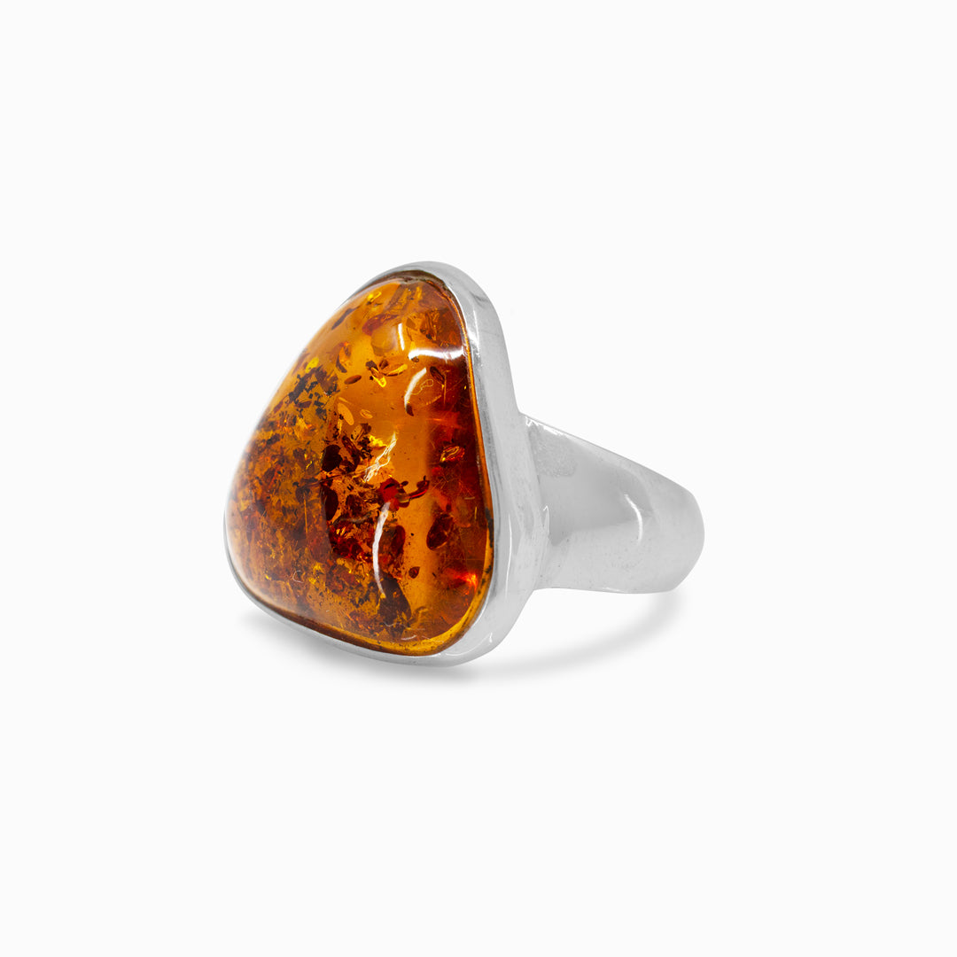 Silver ring with a amber stone on a white background