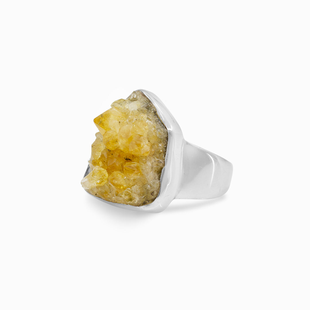 Silver ring with a yellow gemstone on a white background
