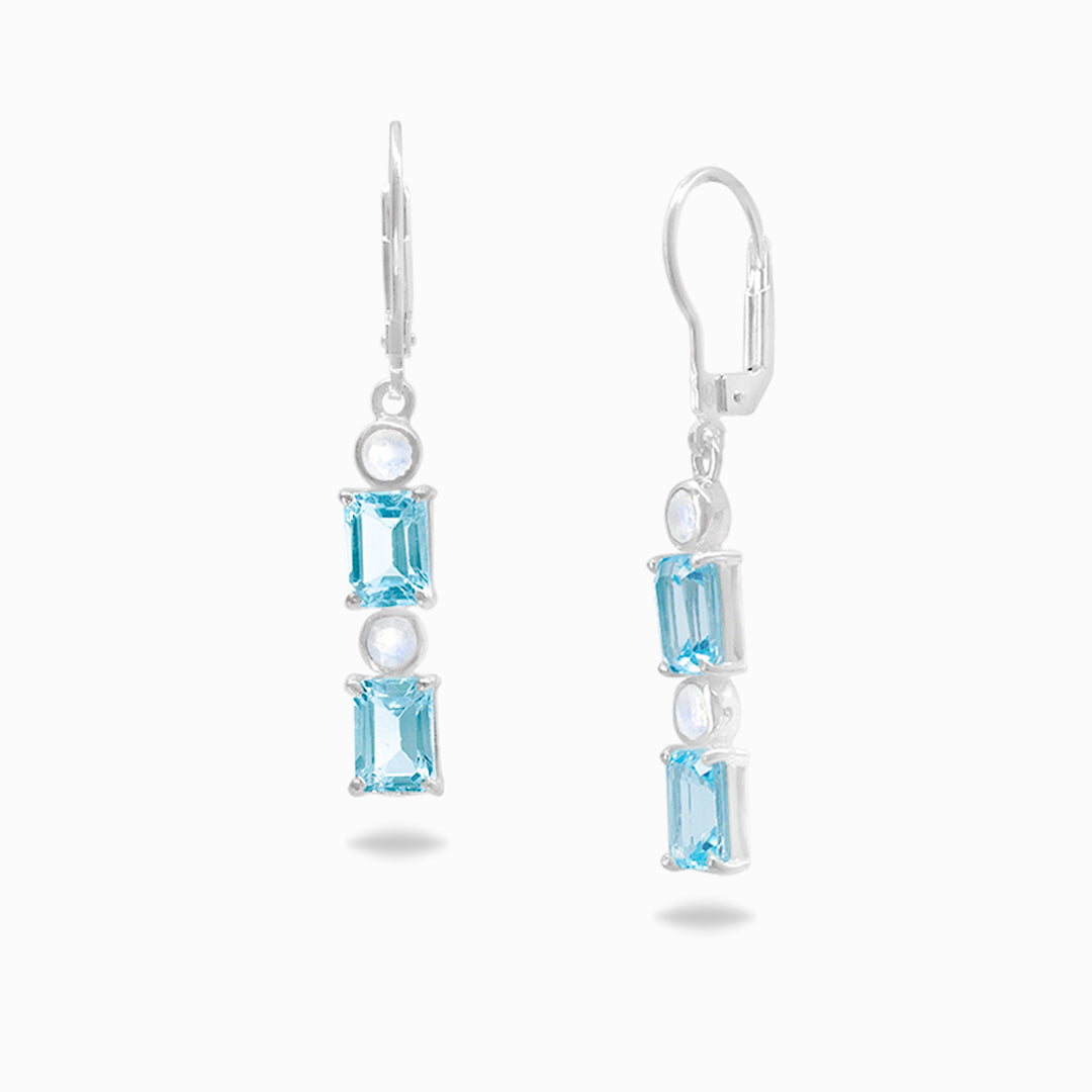 Pair of silver earrings with blue and clear gemstones on a white background