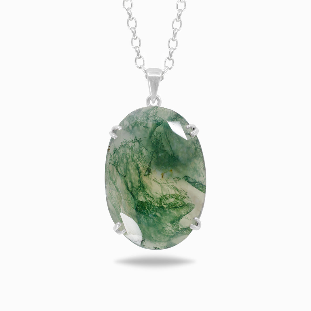 Silver necklace with translucent gemstone with green inclusions on a white background