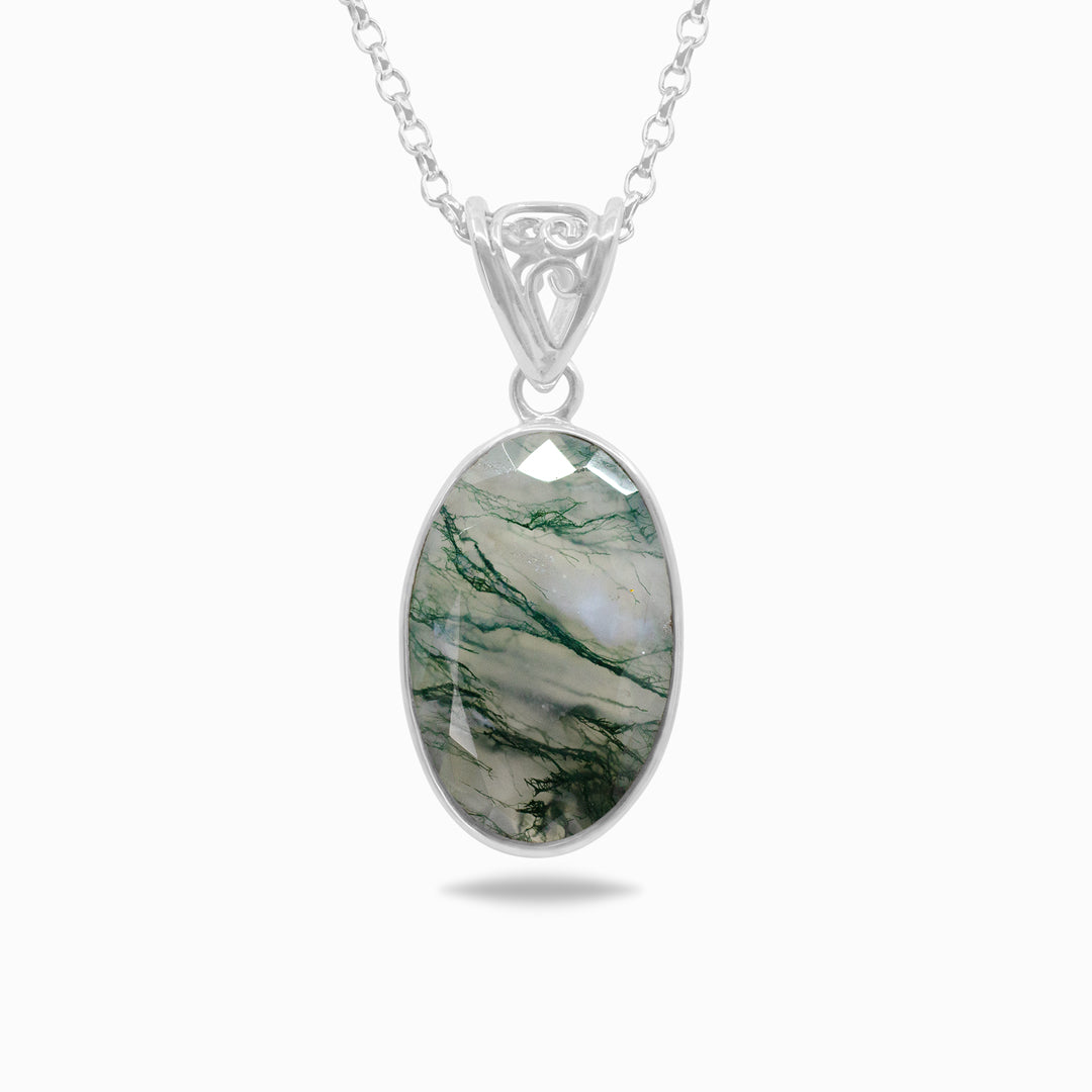 Silver necklace with translucent gemstone with green inclusions on a white background