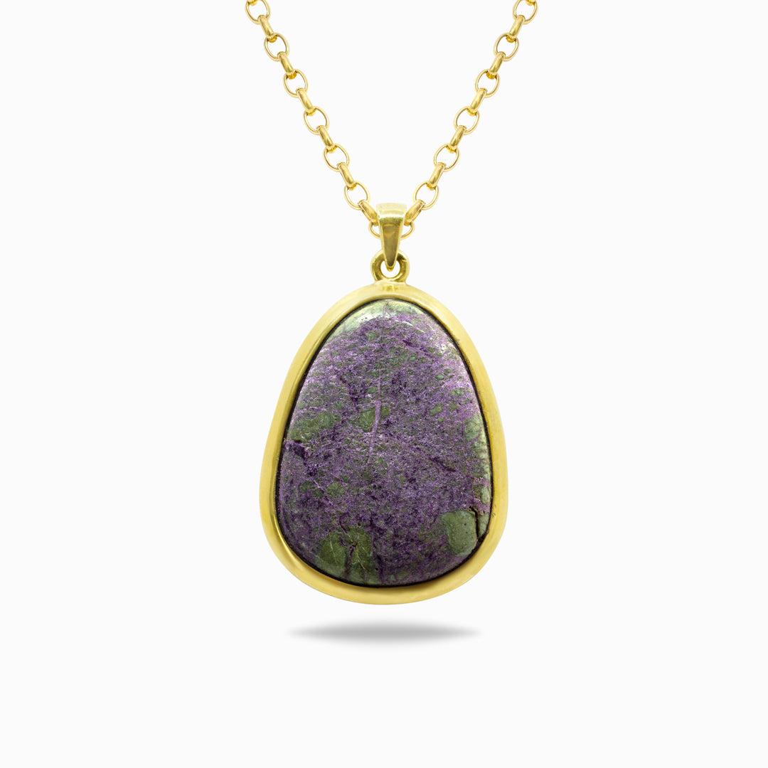 Gold necklace with a purple and green stone on a white background