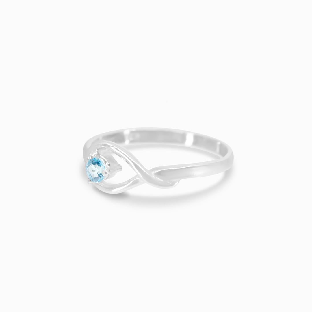 A silver ring featuring a blue gemstone in the centre, set against a white background.