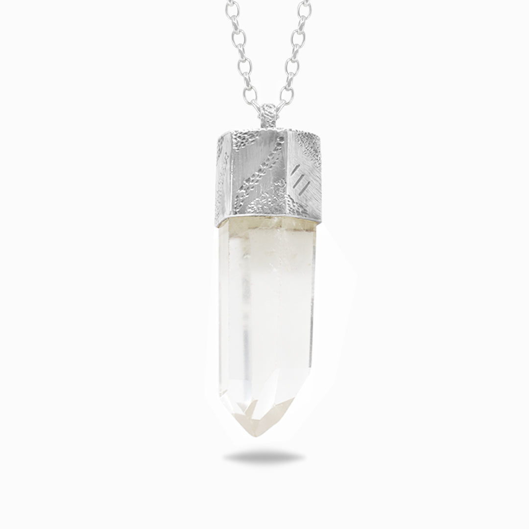 Silver necklace with a clear stone on a white background