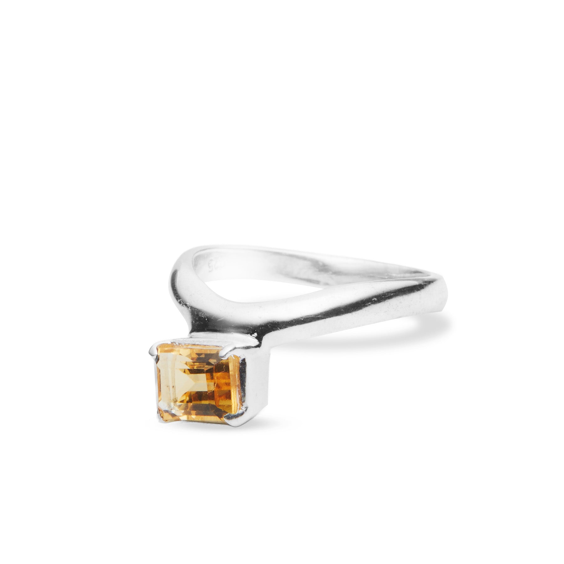 Silver ring with a yellow gemstone on a white background