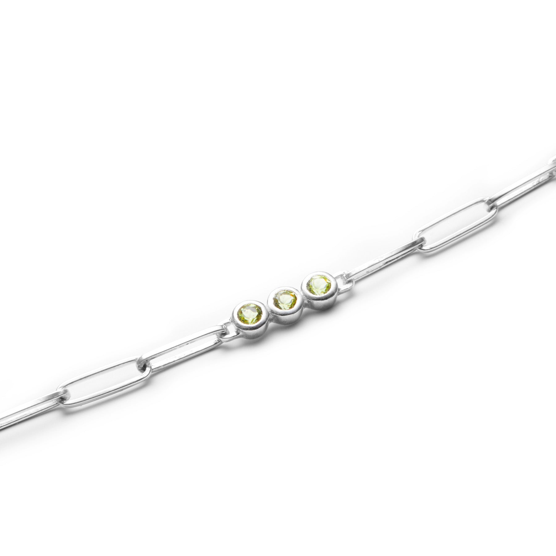 Silver bracelet with green gemstones on a white background