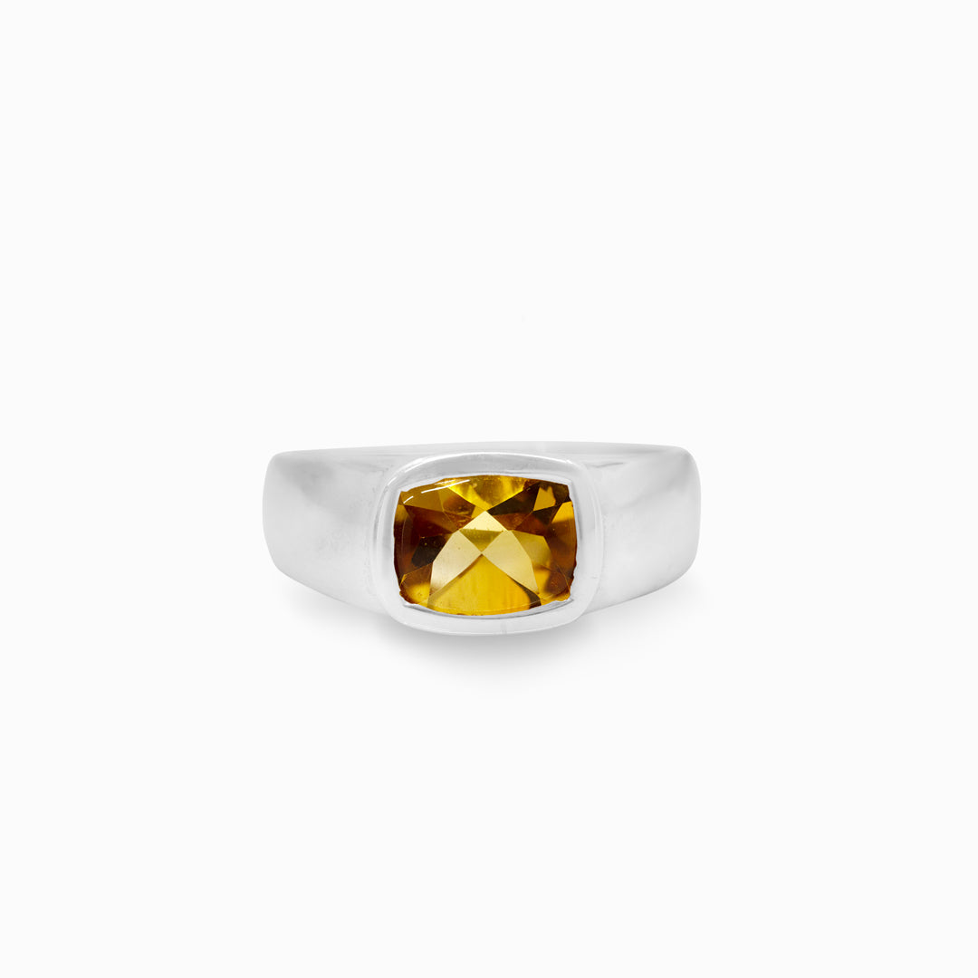 Silver ring with a yellow gemstone on a white background