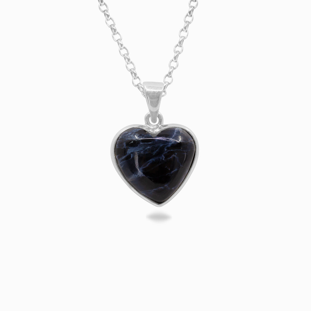 Heart-shaped pendant with blue stone on a silver chain against a white background