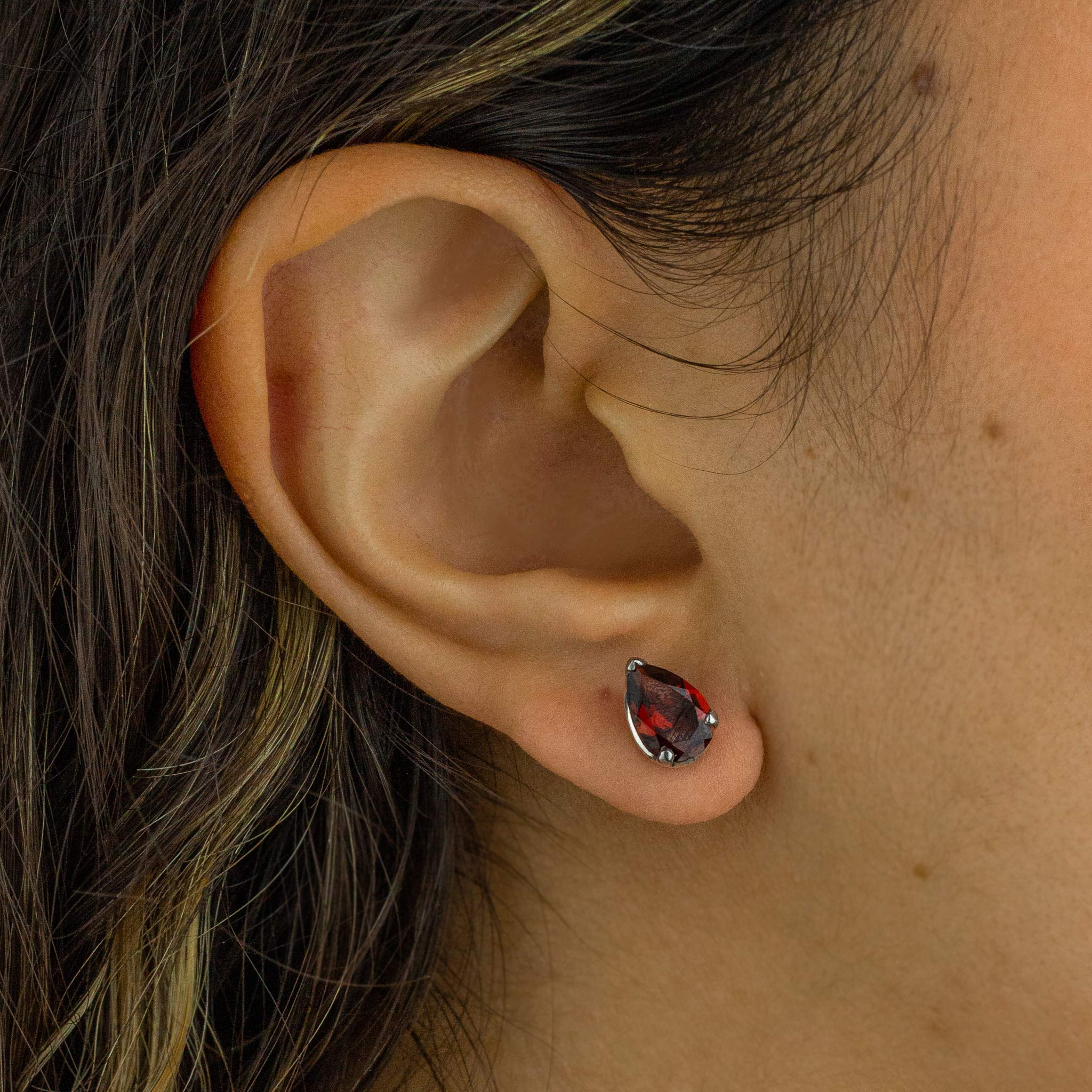 Red garnet and silver earring on ear