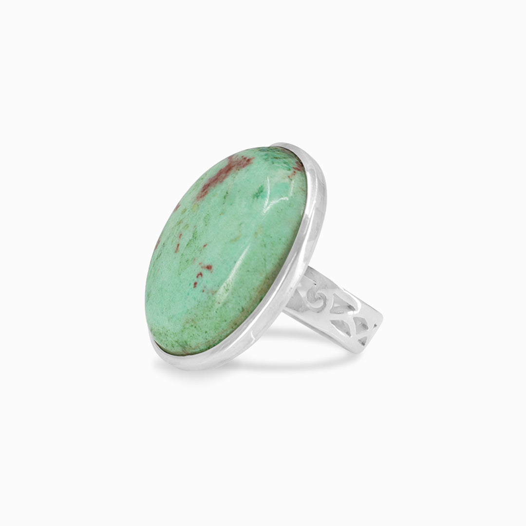 Silver ring with green and red gemstone on a white background