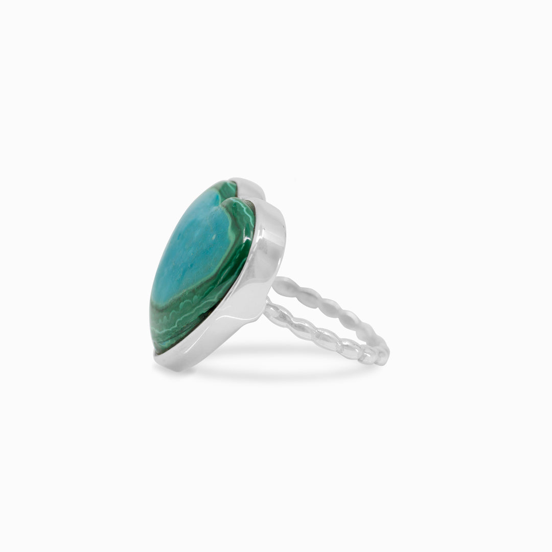Silver ring with a heart-shaped green and blue gemstone on a white background