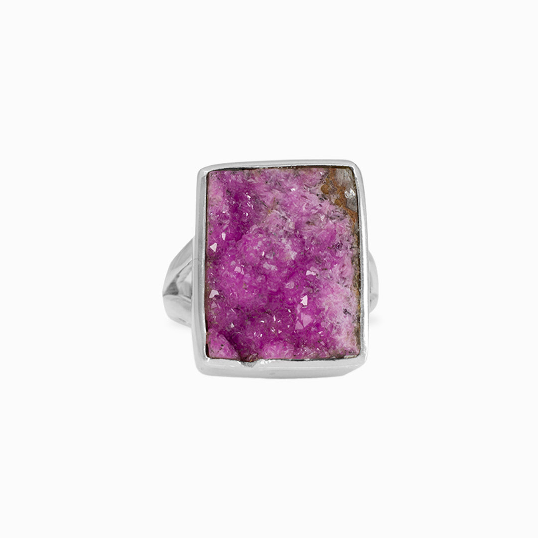 Silver ring with a rough pink gemstone on a white background