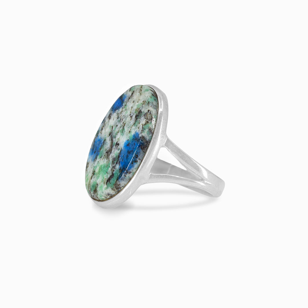 Silver ring with an oval stone featuring green and blue patterns on a white background