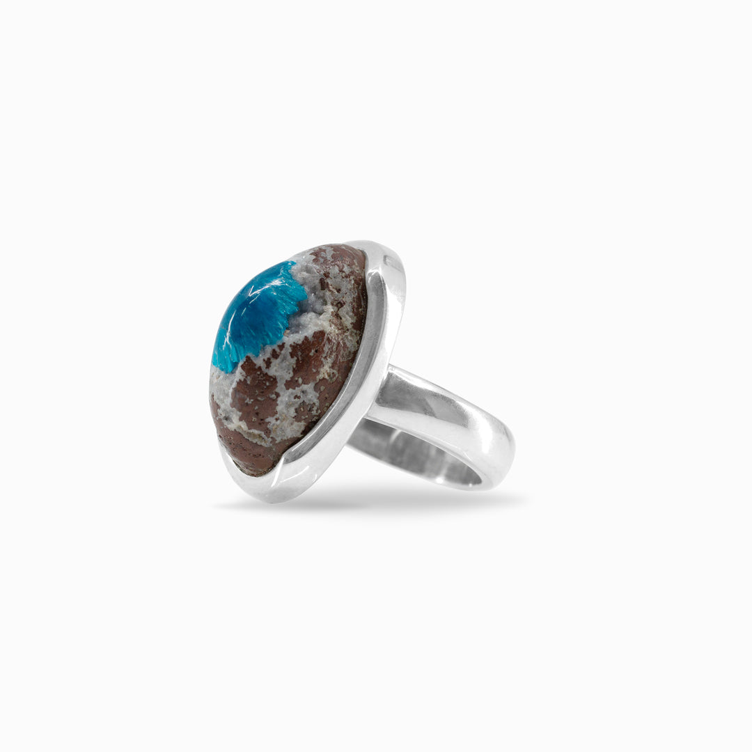 Silver ring with an oval stone featuring a blue centre and brown edges on a white background.