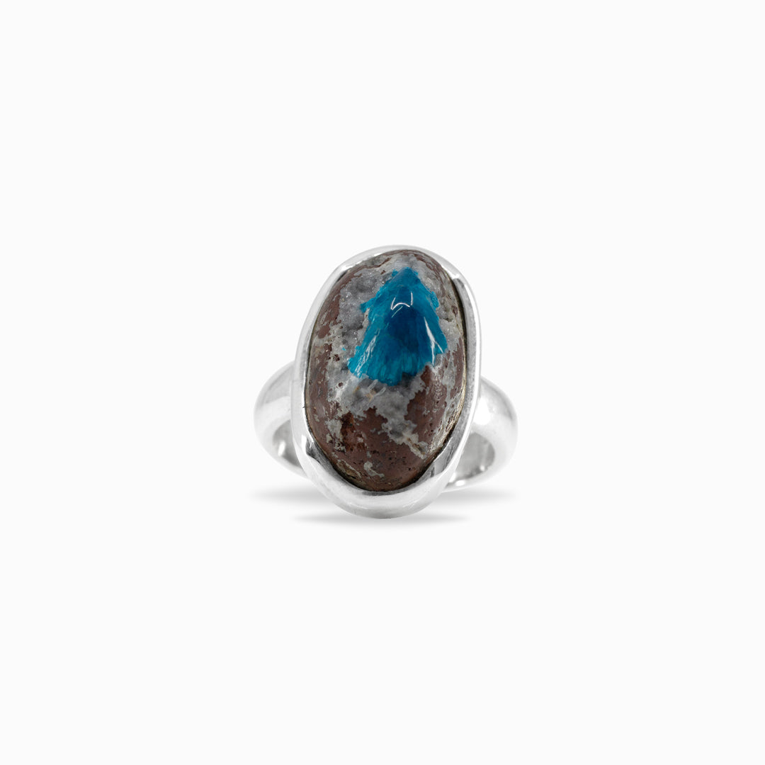 Silver ring with an oval stone featuring a blue centre and brown edges on a white background.