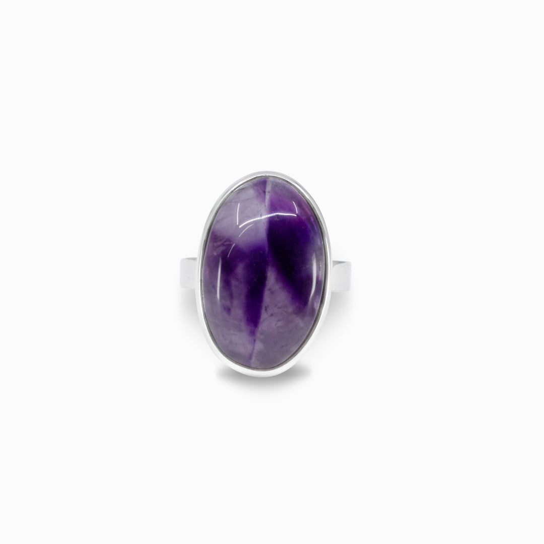 Silver ring with a purple oval stone on a white background