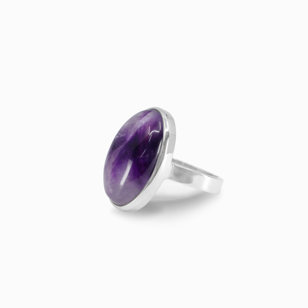 Silver ring with a purple gemstone on a white background