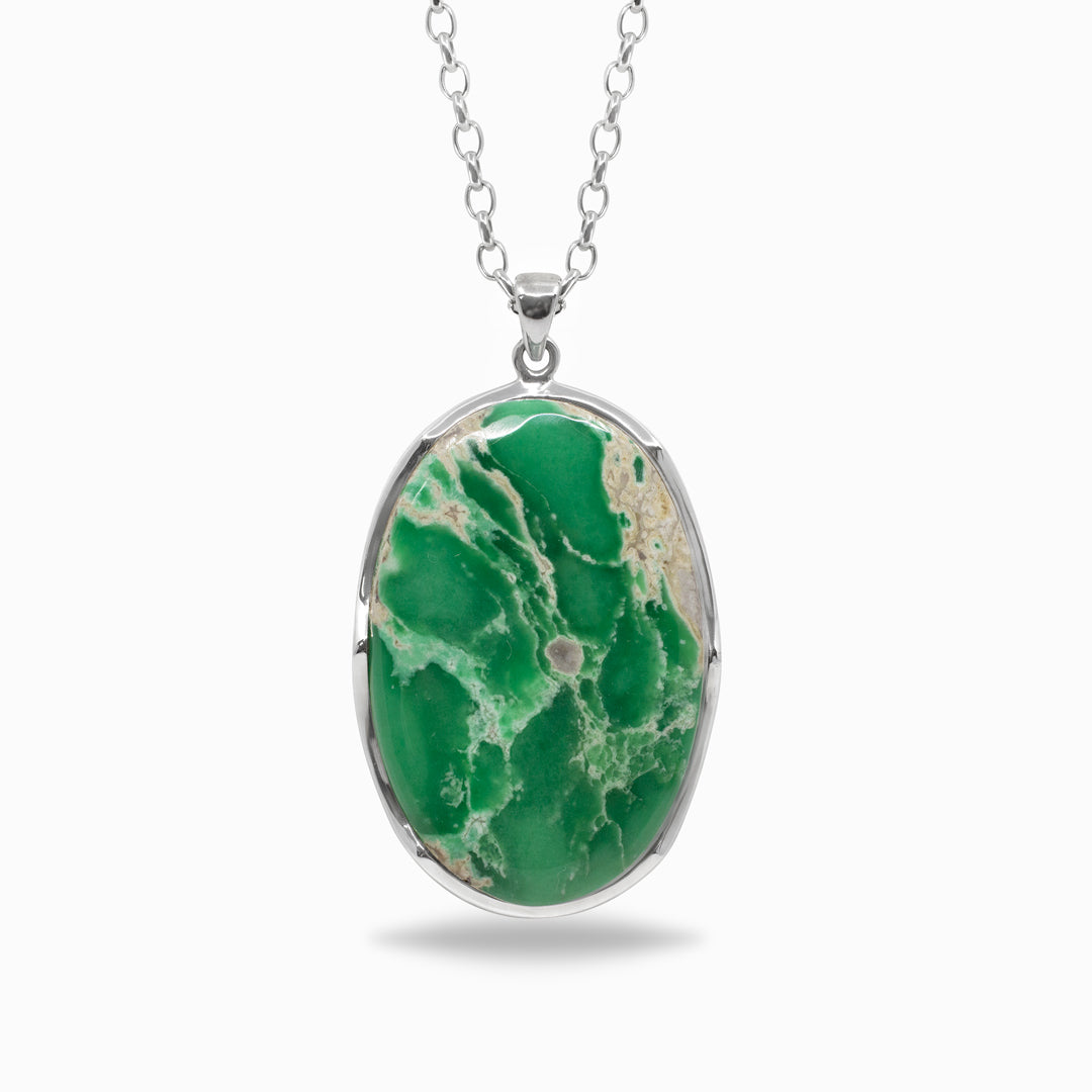 Green stone pendant on a silver chain against a white background