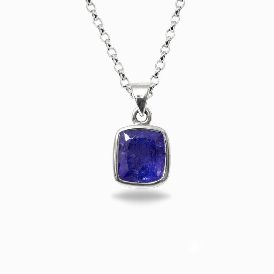 Silver pendant with a blue gemstone on a white background
