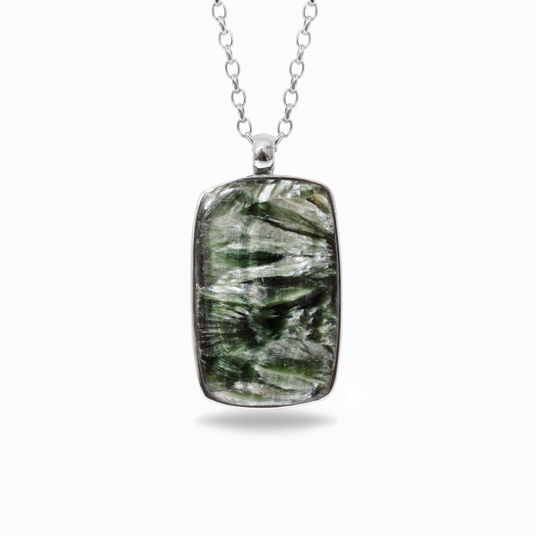 Silver necklace with a rectangular green stone pendant on a white background