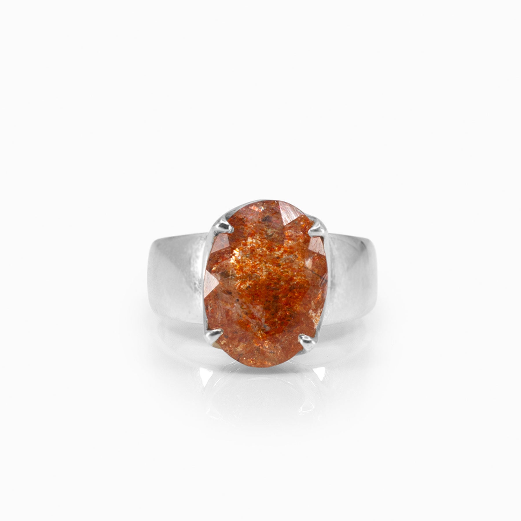 Silver ring with an orange gemstone on a white background