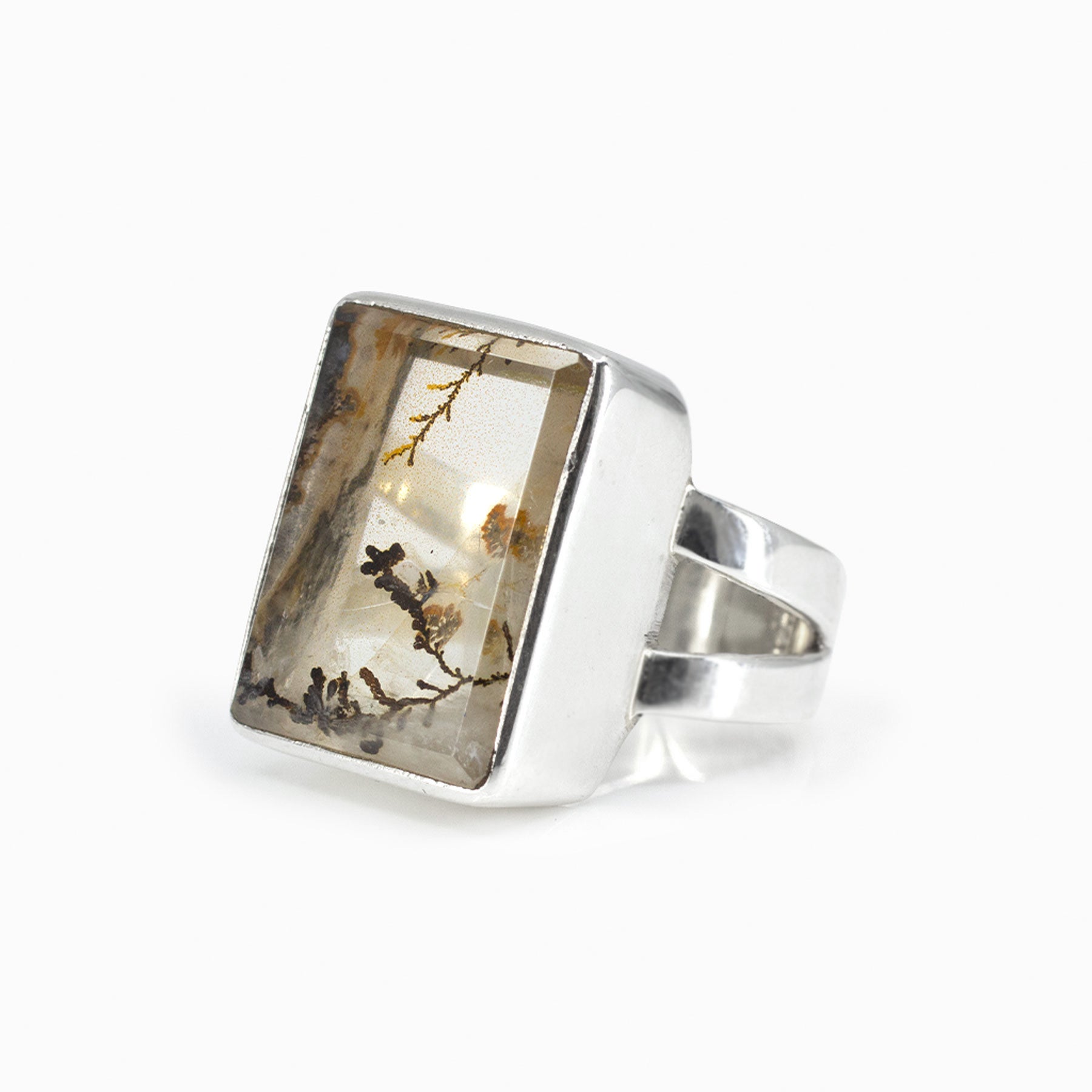 Silver ring with a rectangular clear stone featuring natural patterns on a white background