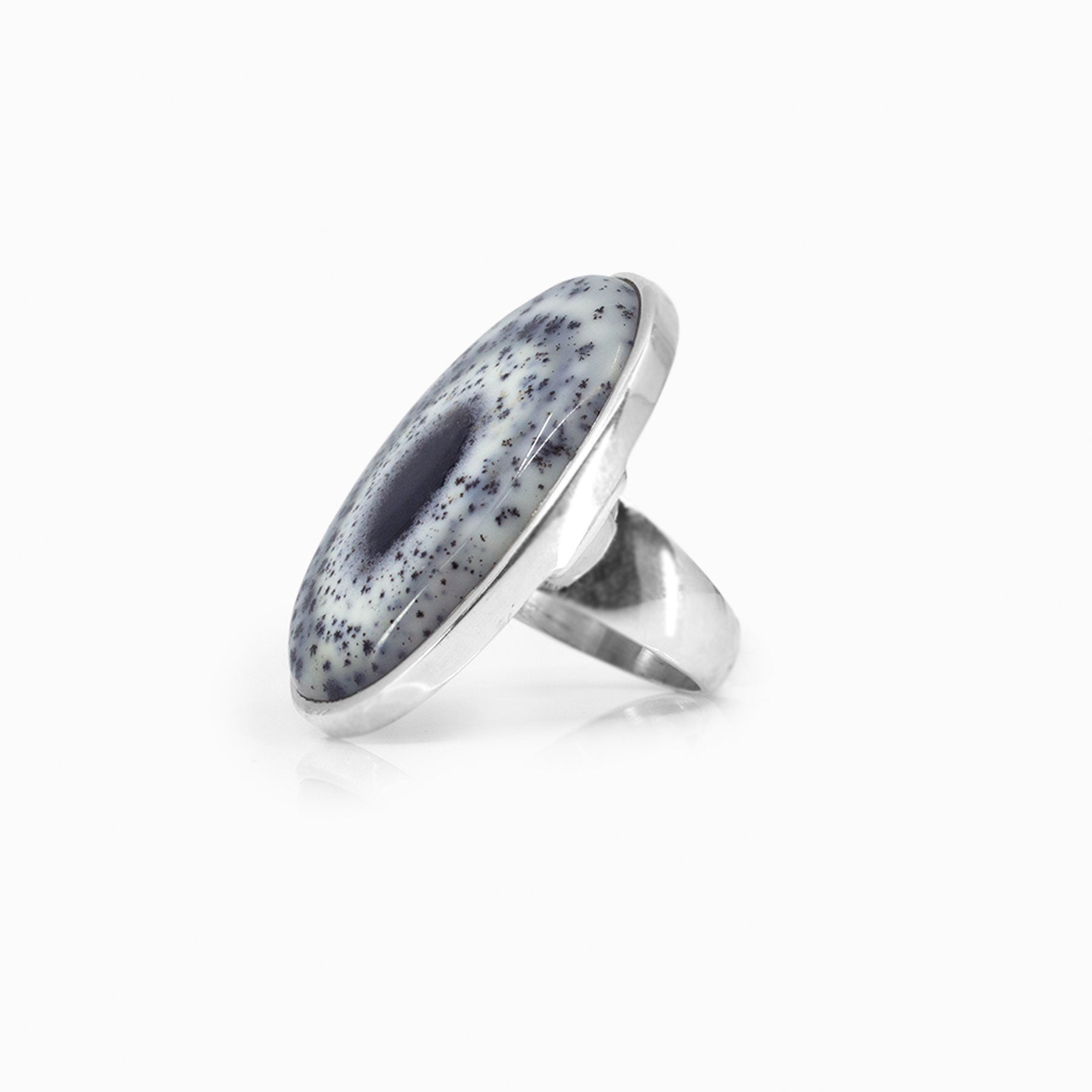 Silver ring with a speckled stone on a white background