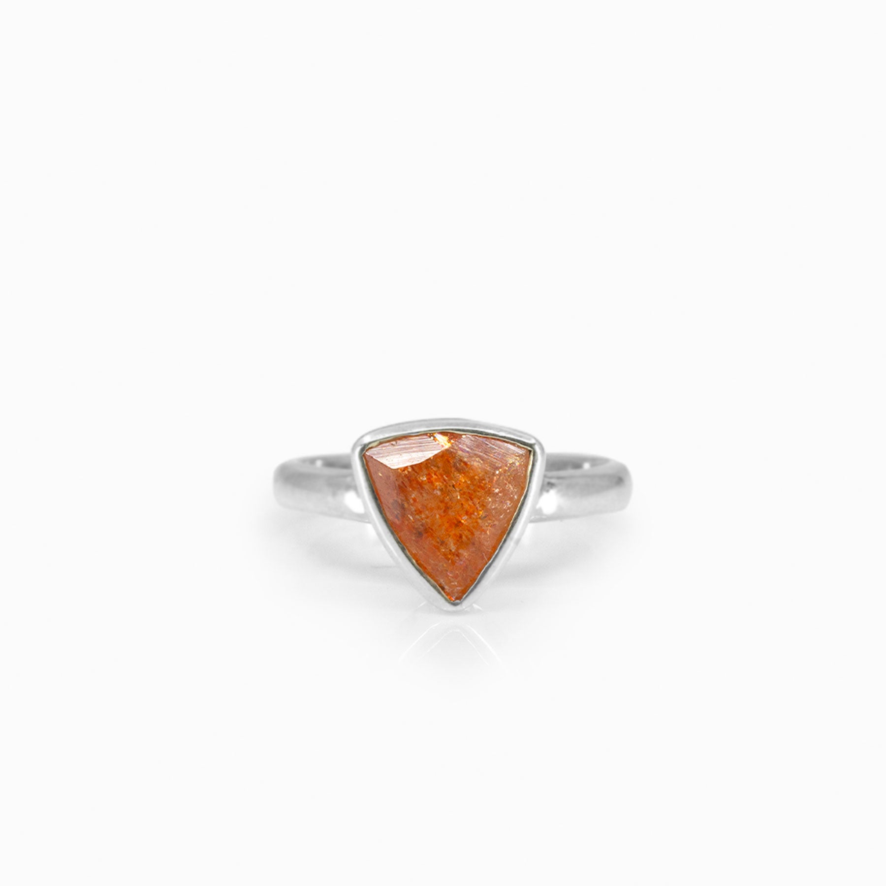 Silver ring with a triangular orange stone on a white background