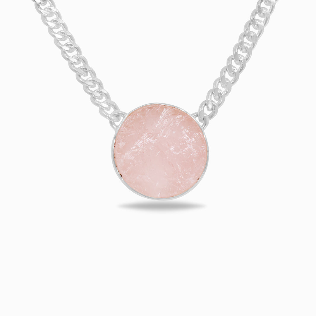Silver necklace with a pink raw gemstone on a white background