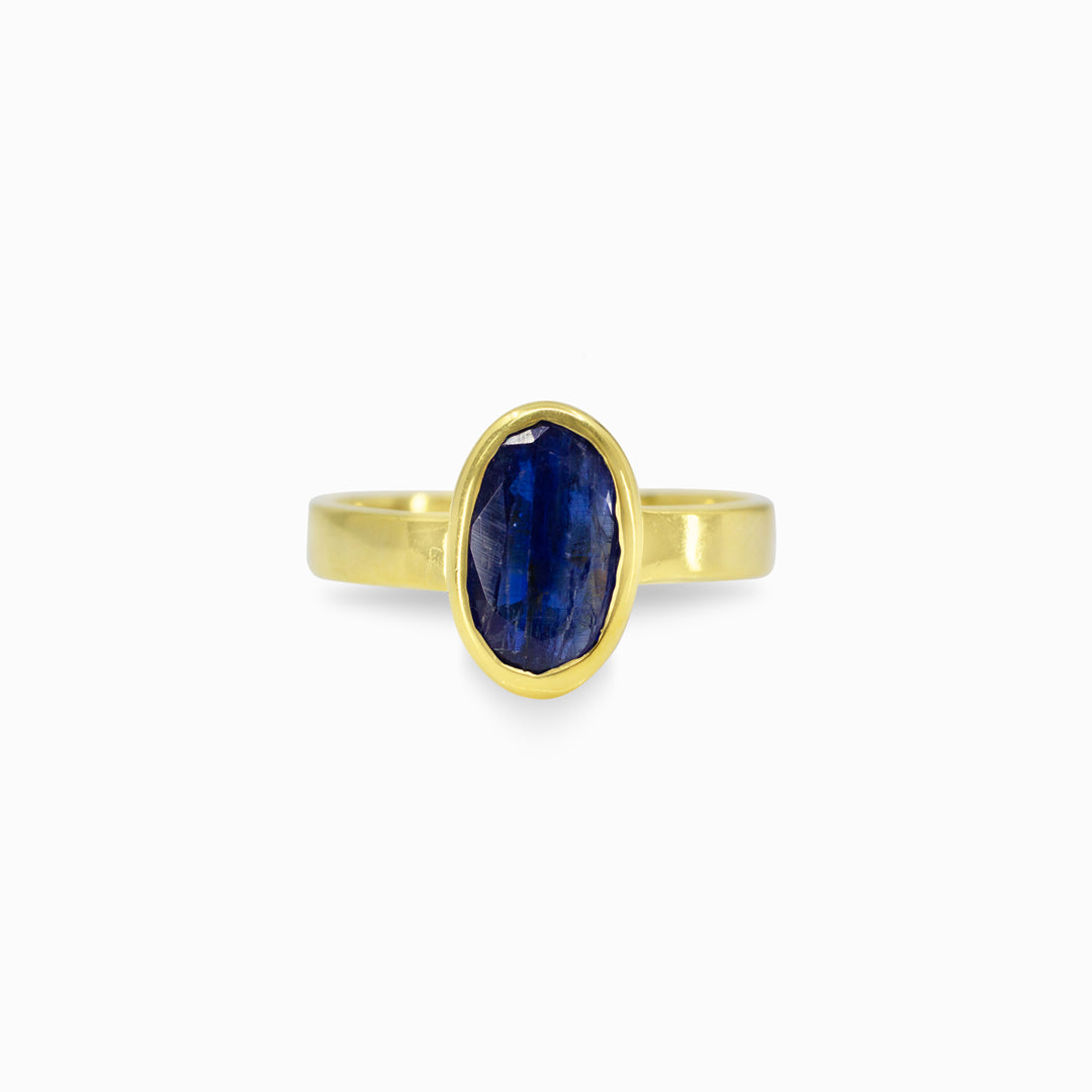 Gold ring with a blue gemstone on a white background