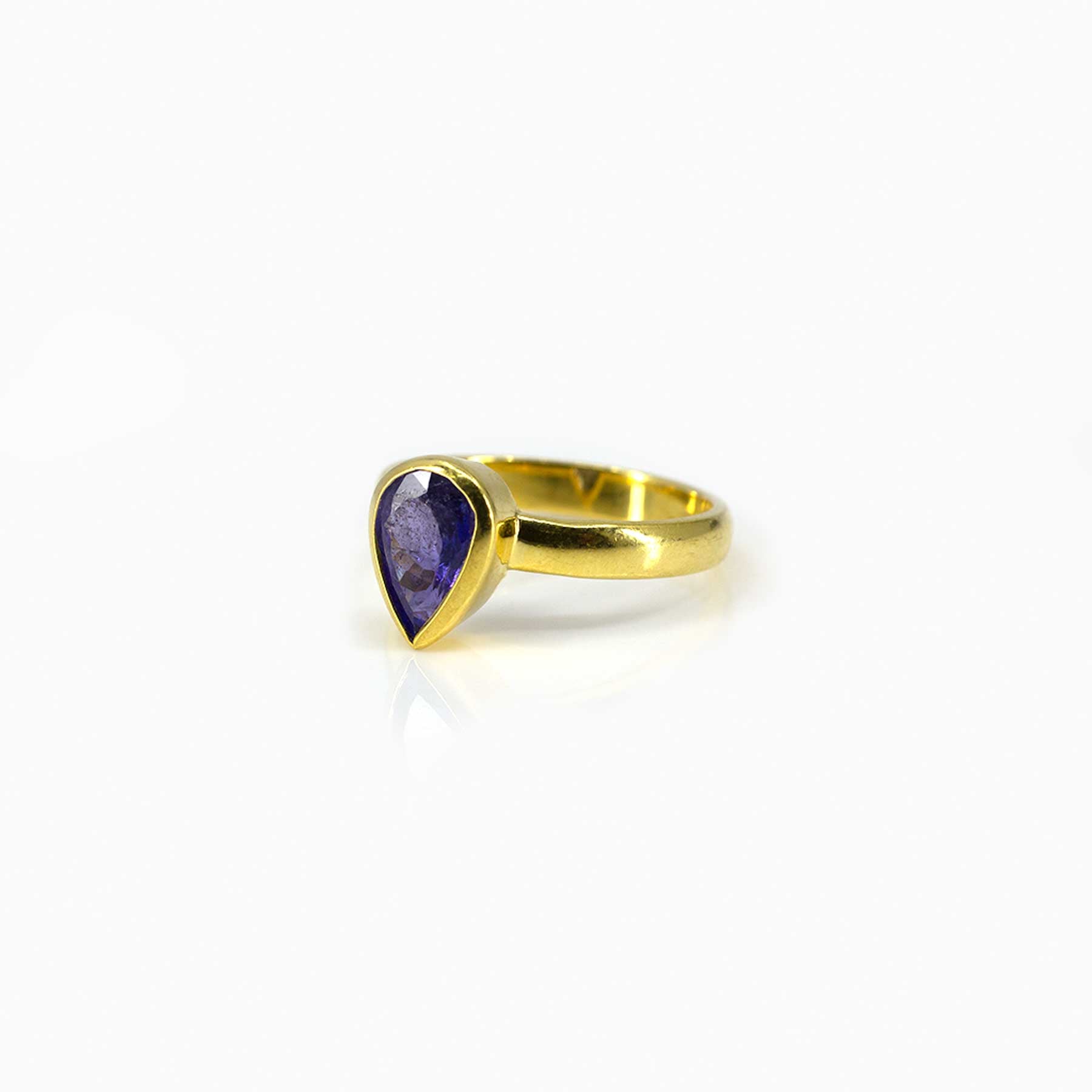 Gold ring with a blue gemstone on a white background