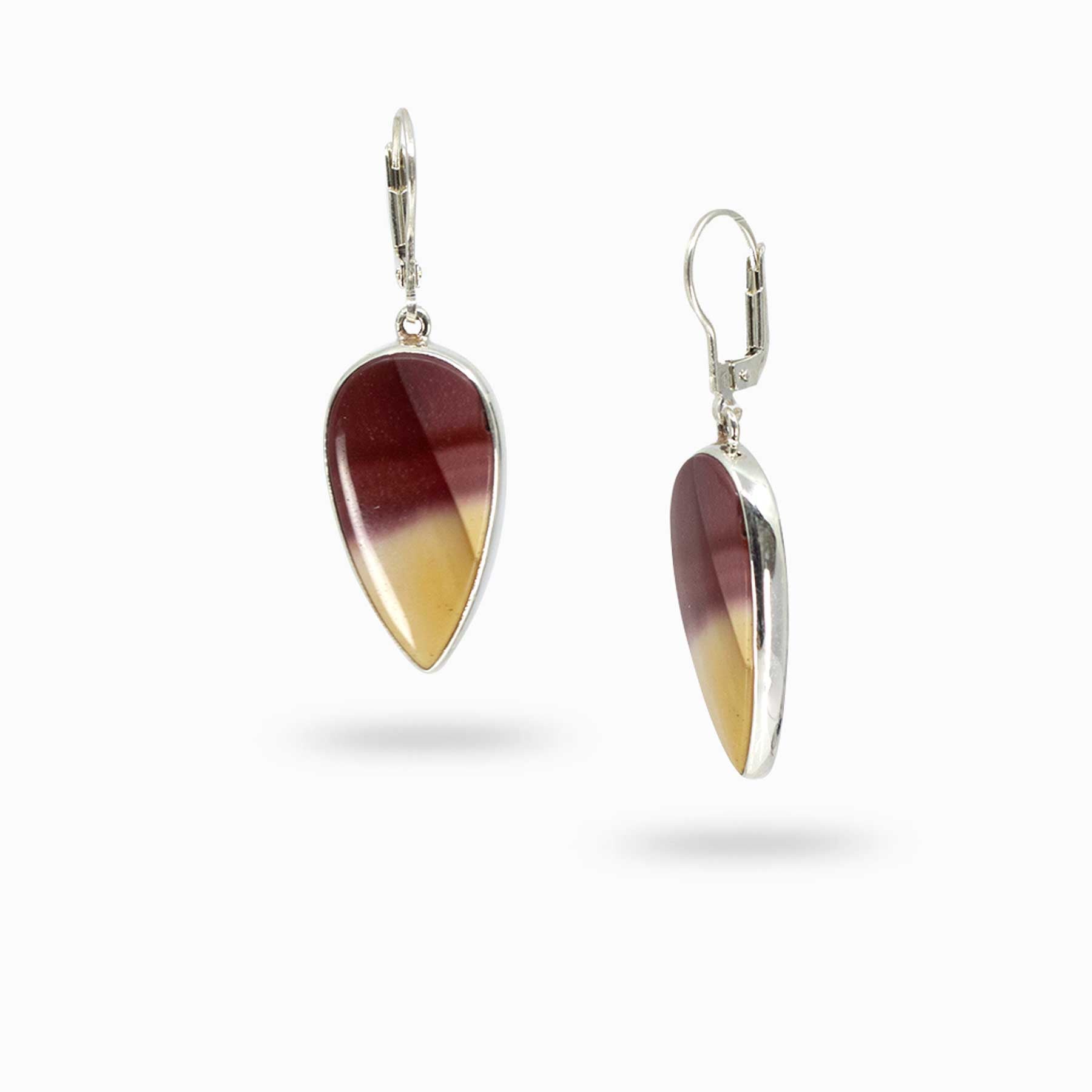 Pair of silver drop earrings with red and yellow gemstones on a white background