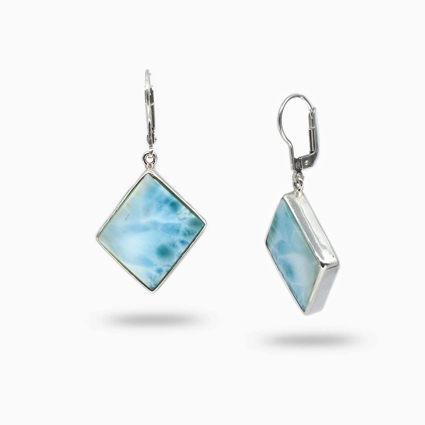 Pair of silver drop earrings with blue and white gemstones on a white background