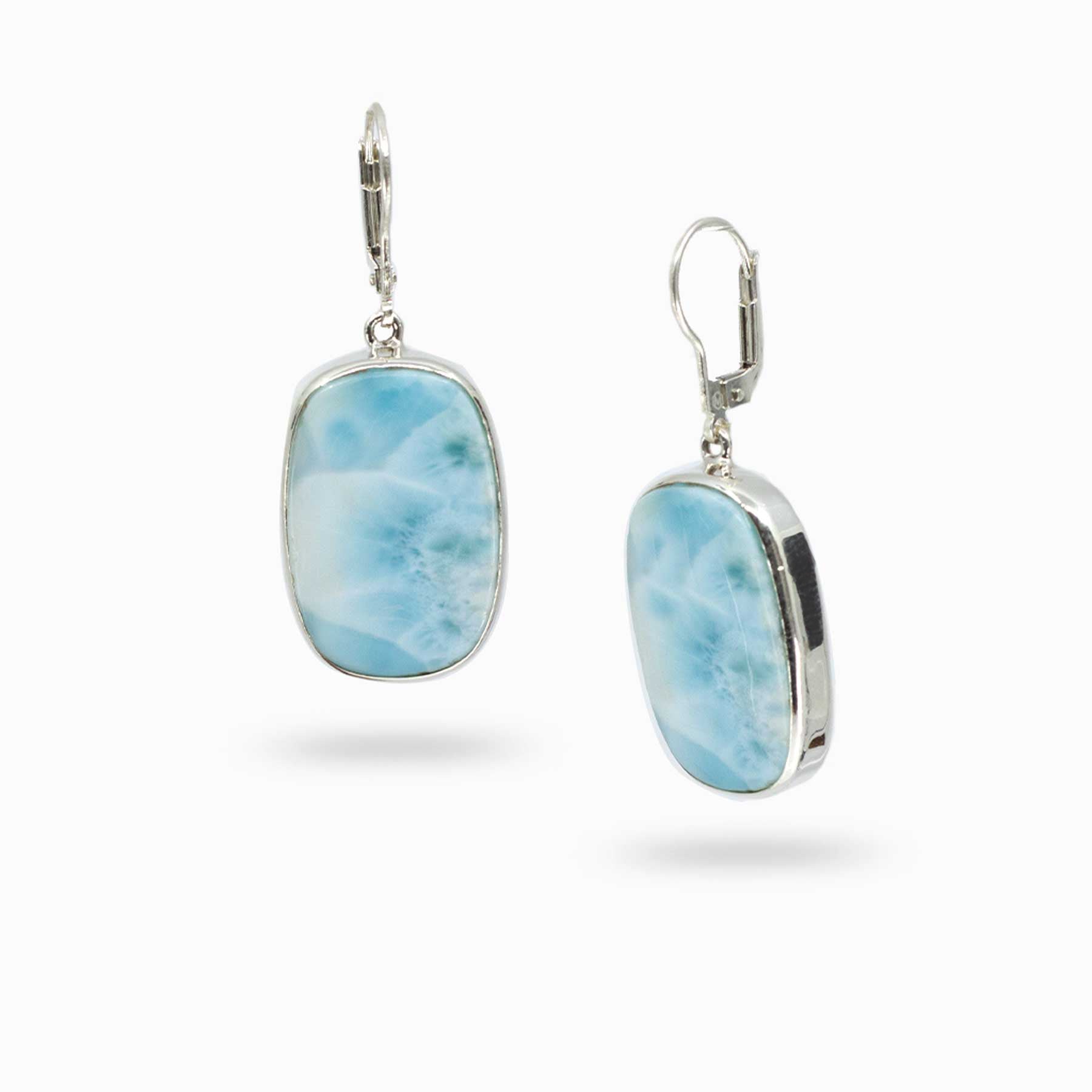 Pair of silver drop earrings with blue and white stones on a white background