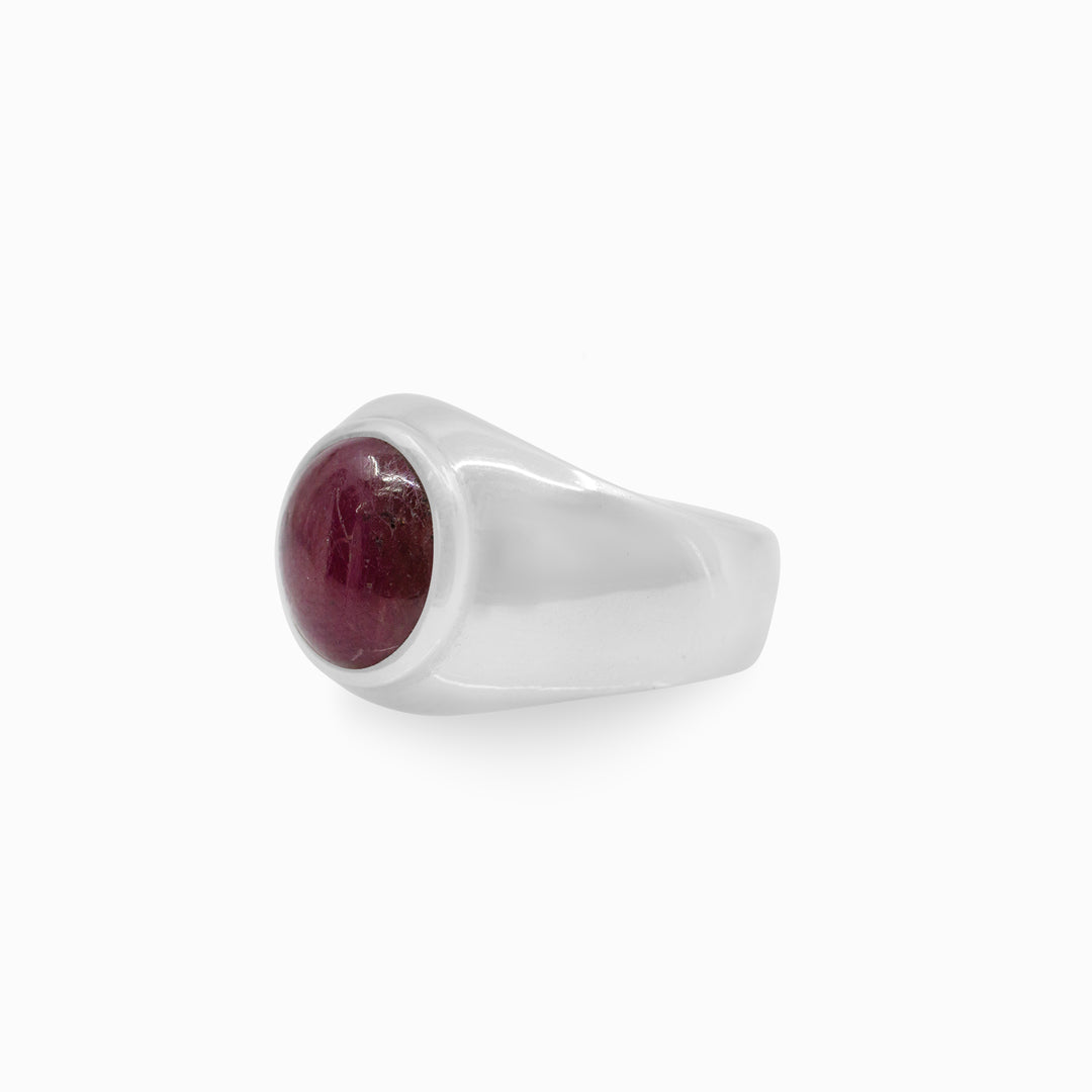 Silver ring with a red gemstone on a white background