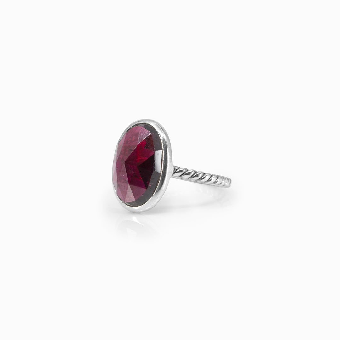 Silver ring with a red gemstone on a white background
