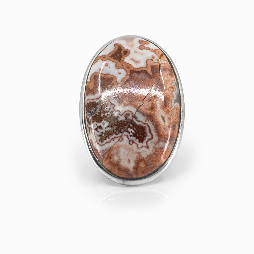 Silver ring with an oval stone with brown, orange and white patterns on a white background