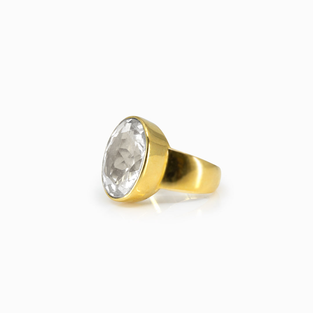 Golden ring with a clear gemstone on a white background