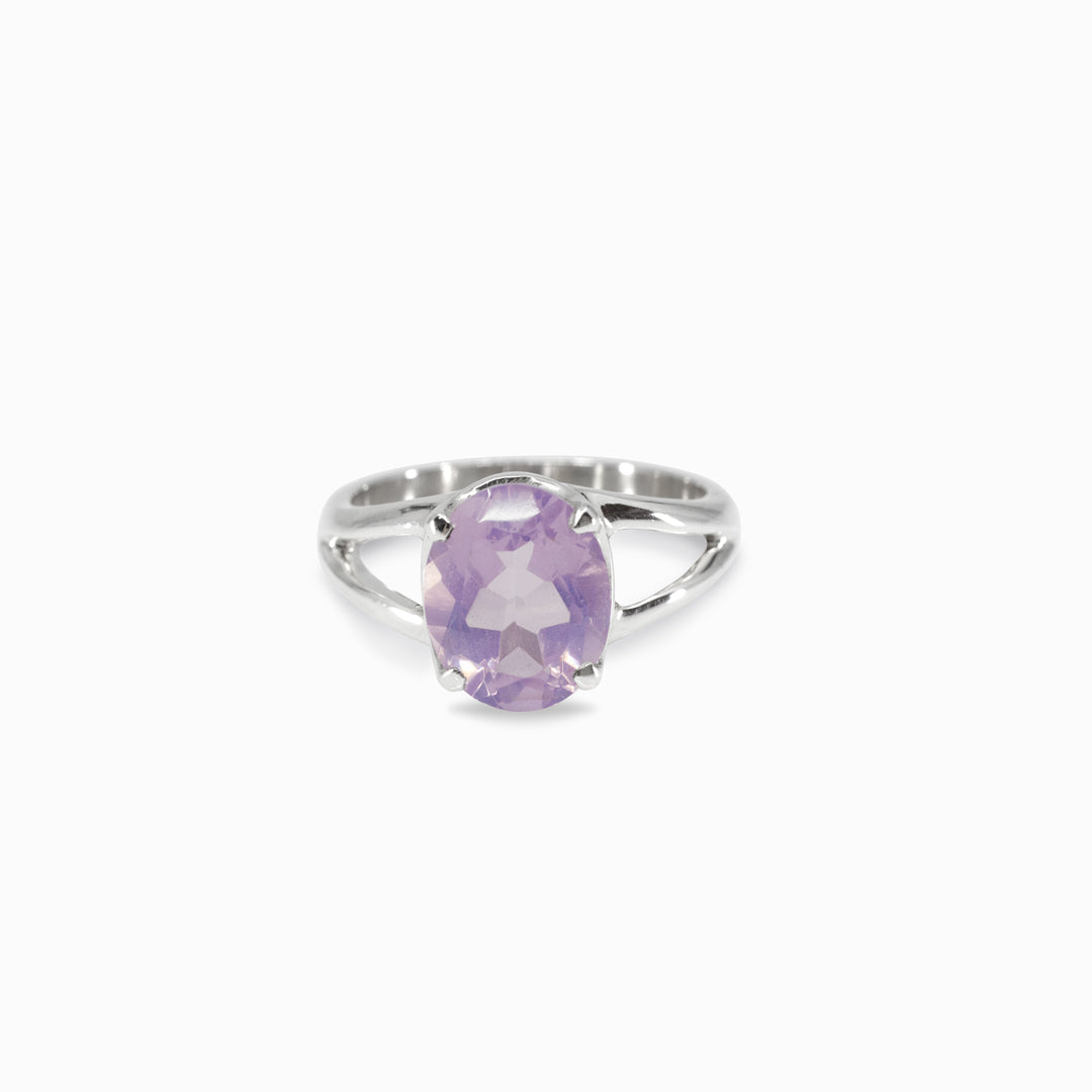 Silver ring with a purple gemstone on a white background