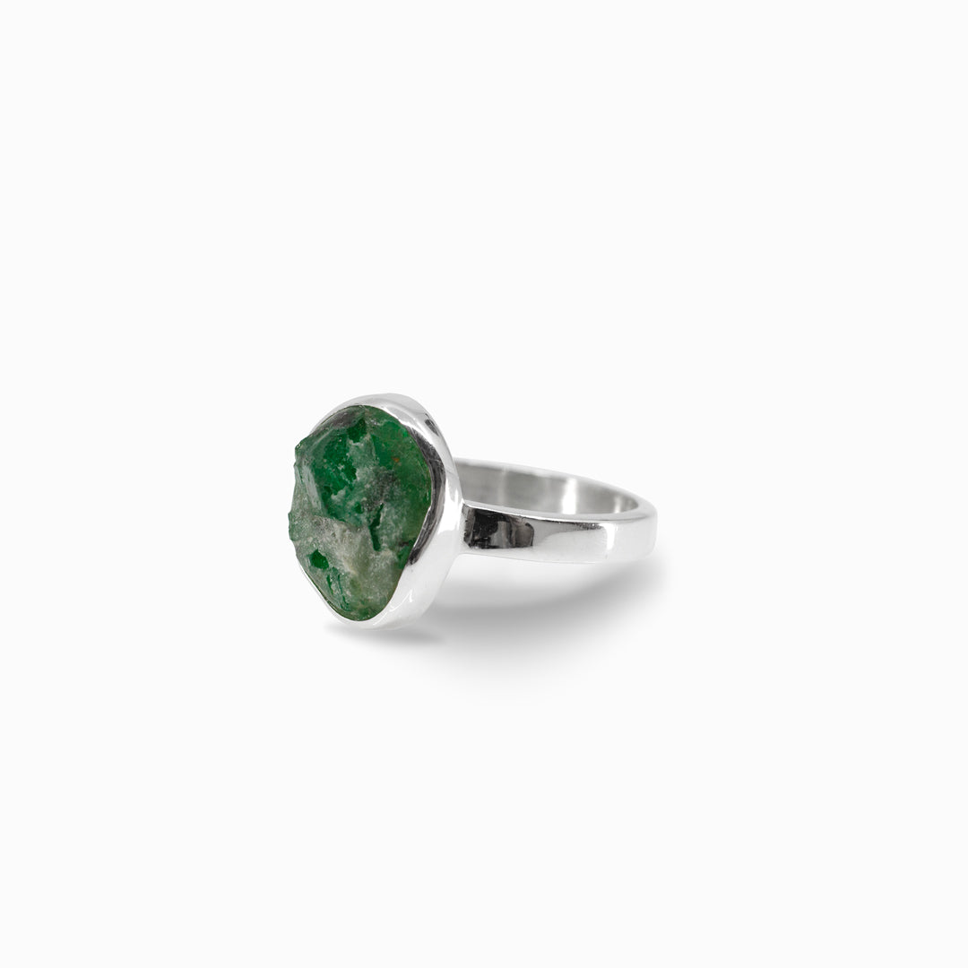 Silver ring with a green stone on a white background
