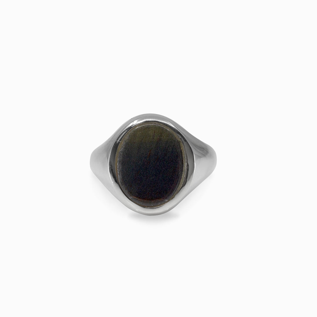 Silver ring with a dark stone on a white background