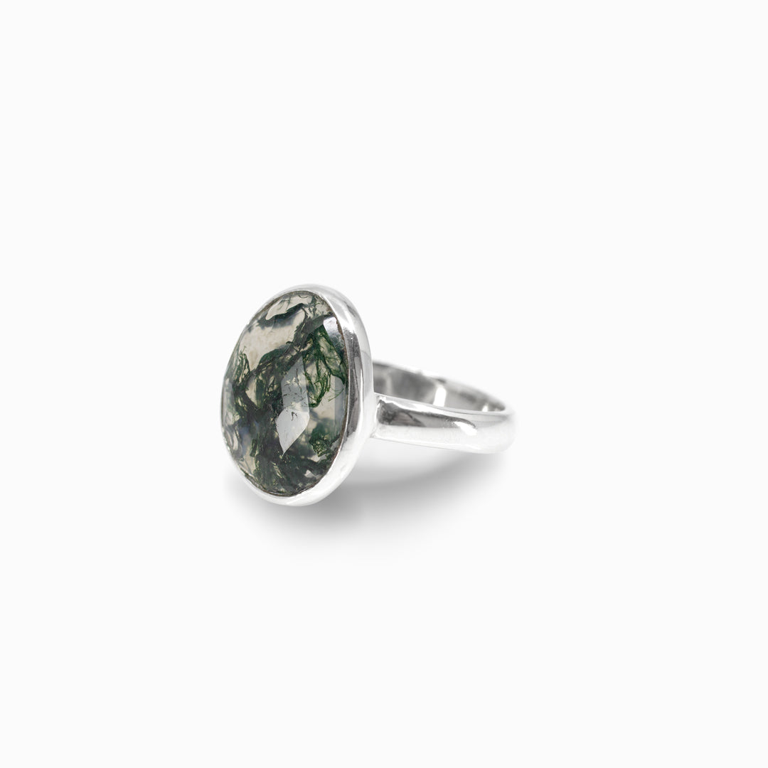 Silver ring with a green marbled stone on a white background