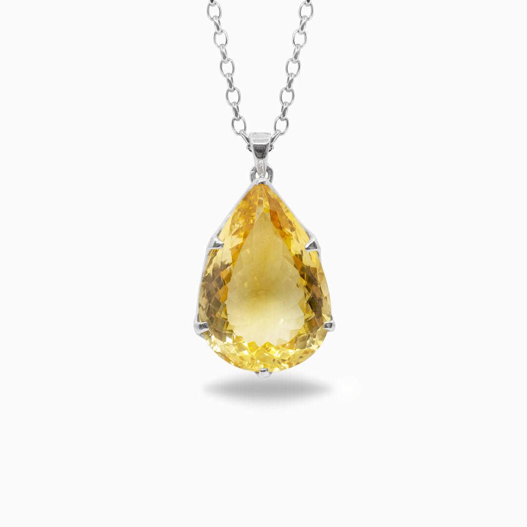 Teardrop-shaped yellow gemstone pendant on a white background