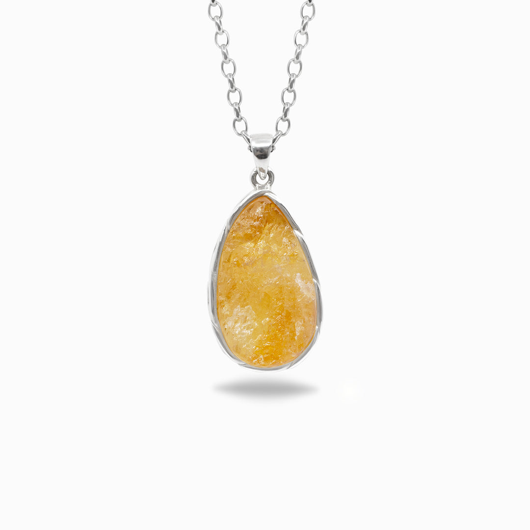 Teardrop-shaped pendant with a yellow gemstone on a silver chain against a white background
