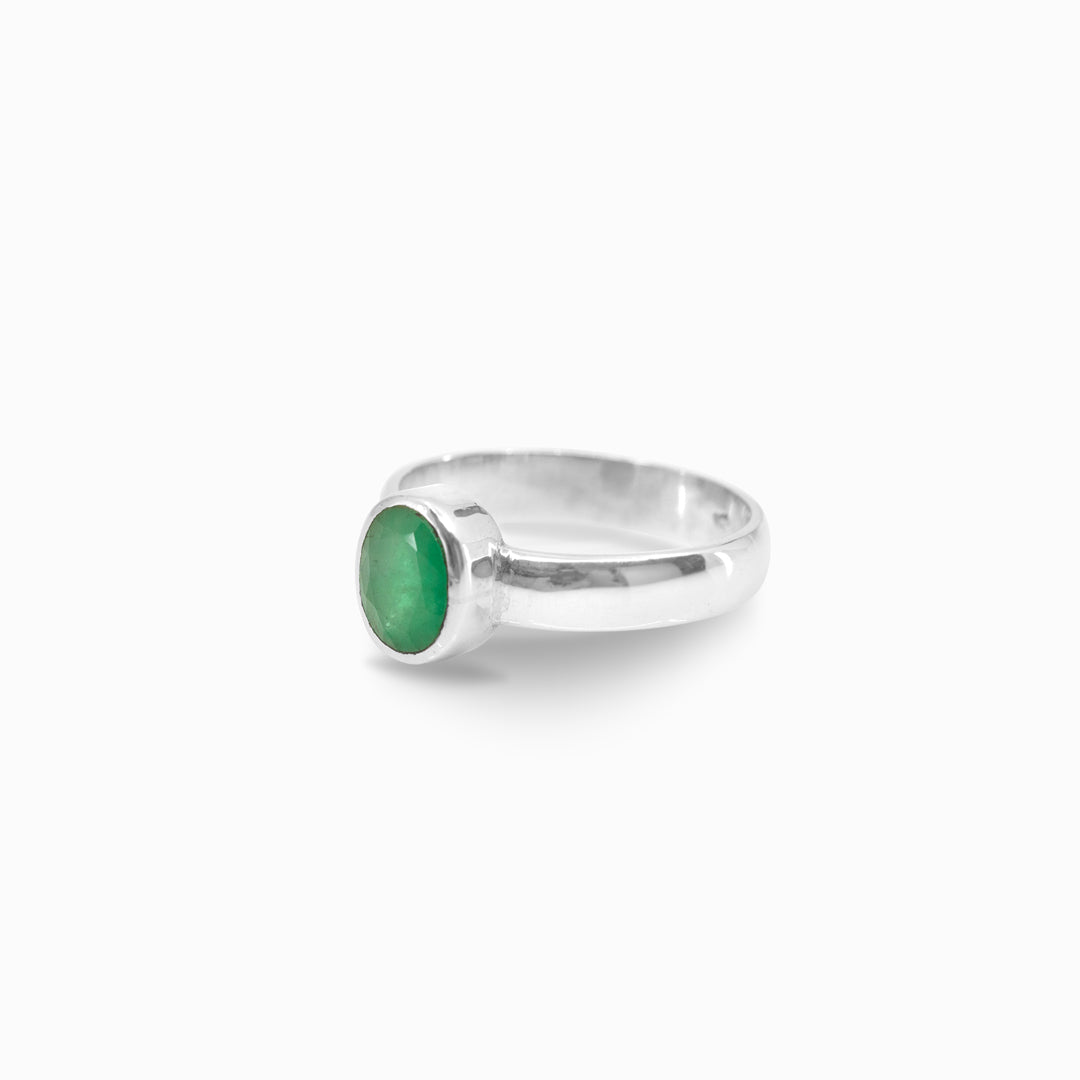 Silver ring with a green gemstone on a white background