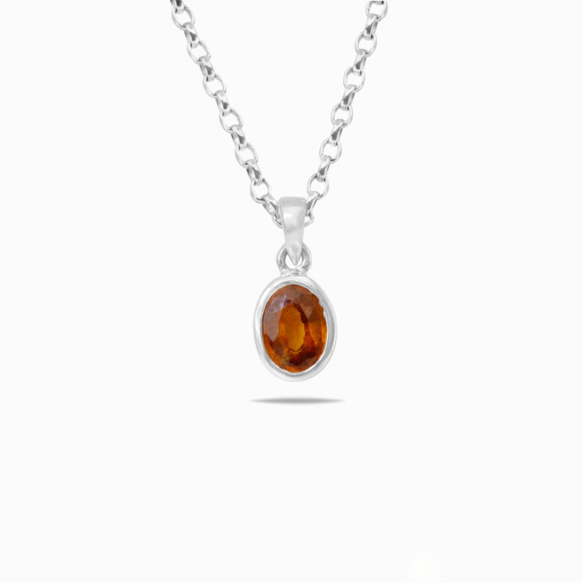 Silver necklace with a pendant featuring an orange gemstone on a white background