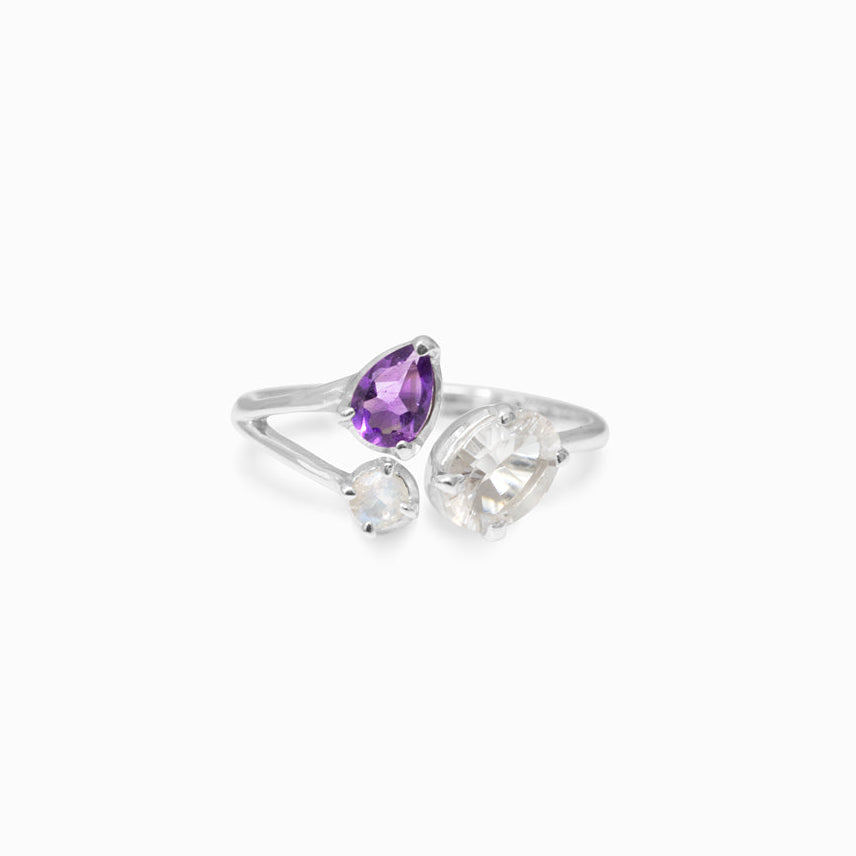 Silver ring with purple and clear gemstones on a white background