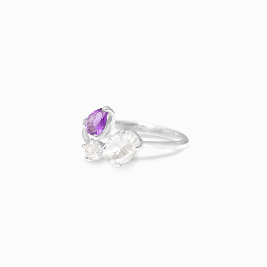 Silver ring with purple and clear gemstones on a white background